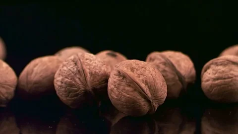 Fresh walnuts on a dark glossy background Stock Footage 74703272