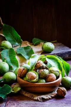 Fresh walnuts in a green shell with leaf, vintage wooden background, selectiv Foto stock