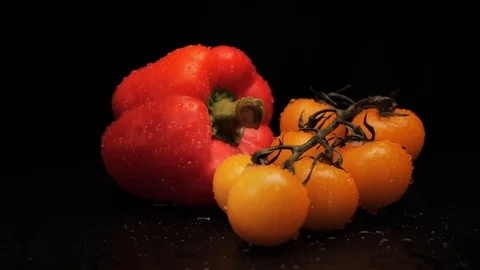 Fresh washed red bell pepper and yellow cherry on a black background. Close-up Stock Footage 127457950