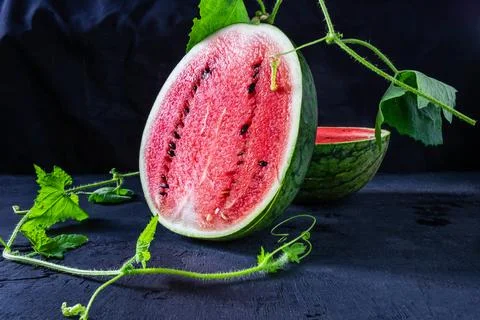 Fresh Water melon fruit cut in half on a black background. Stock Photos