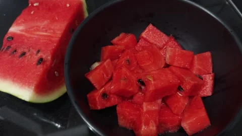 Fresh watermelon piece with its vibrant red flesh and visible seeds, beside a Stock Footage 345515612