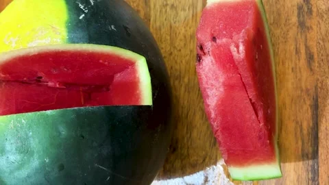Fresh watermelon slice with juicy red flesh and whole watermelon on wooden table 库存影片 336536562