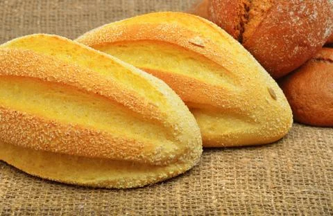 Fresh wheat buns on the sacking background. Stock Photos