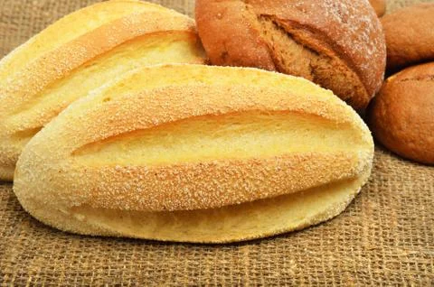 Fresh wheat buns on the sacking background. Stock Photos