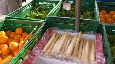 Fresh white asparagus, oranges and greens at outdoor market Stock Footage 333977689