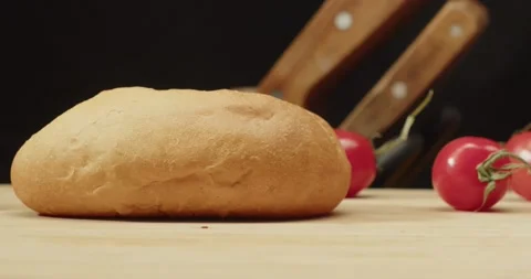 Fresh white bread buns close up with cherry tomatos and knives at background Stock Footage 236321644