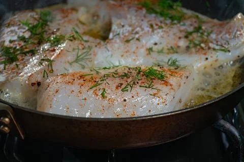 Fresh White Cod Fillets Sizzling in a Frying Pan with Fresh Dill Stock Photos