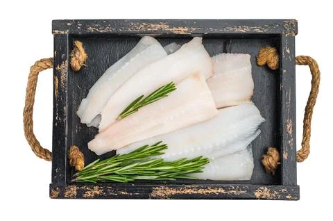 Fresh white fish fillets cod hake pollock on round metal plate isolated on .. Stock Photos