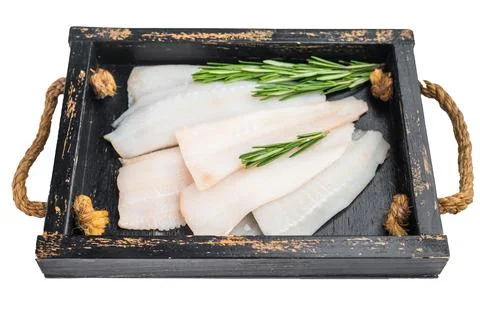 Fresh white fish fillets cod hake pollock on round metal plate isolated on .. Stock Photos