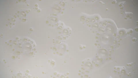 Fresh white milk with milk bubbles popping in the kitchen Stock Footage 331536947