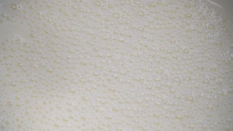 Fresh white milk with milk bubbles popping in the kitchen Stock Footage 334046467