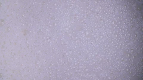 Fresh white milk with milk bubbles popping in the kitchen Видео 334652254
