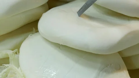 Fresh white suluguni cheese stack in marketplace as metal knife tests textu.. Stock Footage 332408652