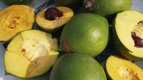 Fresh Whole and Sliced Peruvian Lucuma Fruit in a White Bowl Vídeo Stock 344985169