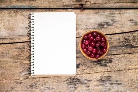 Fresh wild berries with paper notebook on wooden table. Menu background top.. Stock Photos
