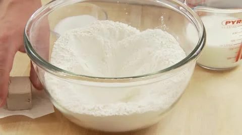 Fresh yeast being crumbled and added to a well in flour 스톡 동영상 24639968