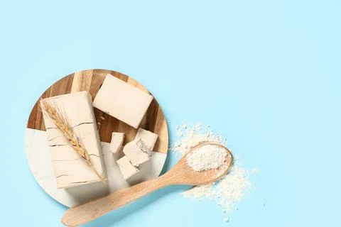 Fresh yeast blocks with wheat ear and flour on a wooden board, baking ingredi Stock Photos