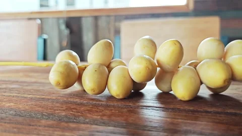 Fresh Yellow Date Palm Branch on Warm Wooden Table Closeup. Stock Footage 340487549