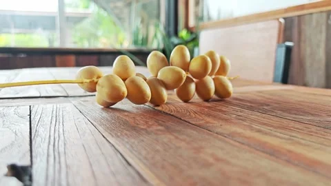 Fresh Yellow Date Palm Branch on Warm Wooden Table. Stock Footage 340488249