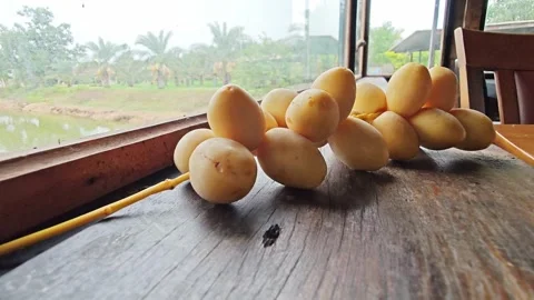 Fresh Yellow Date Palm Bunch on Wooden Table by Window. Stock Footage 340488278