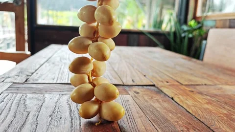 Fresh Yellow Date Palm Bunch Hanging Vertically Over Wooden Table. Stock Footage 340488290