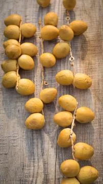 Fresh yellow dates on a sprigs on rustic wooden background. Flat lay Foto stock