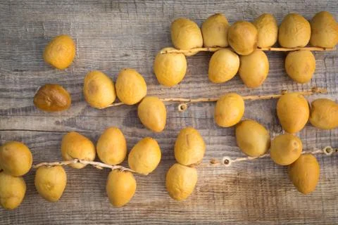 Fresh yellow dates on a sprigs on rustic wooden background. Flat lay 2 Stock Photos