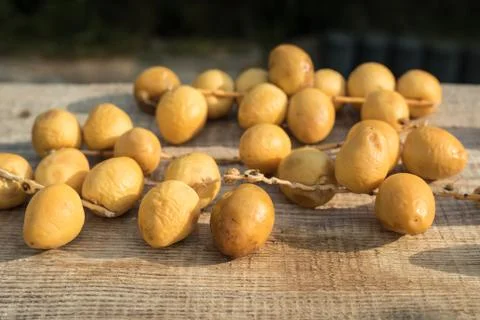 Fresh yellow dates on a sprigs on rustic wooden background. Side view Stock Photos