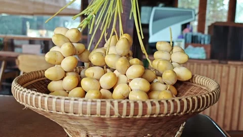 Fresh Yellow Dates in Traditional Woven Bamboo Basket on Table. Stock Footage 340487577