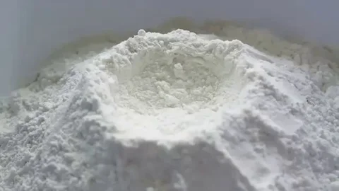 Fresh yellow egg being broken and dropped down into white baking flour Video stock 98247576