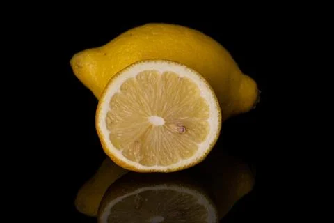 Fresh yellow lemon isolated on black glass Stock Photos