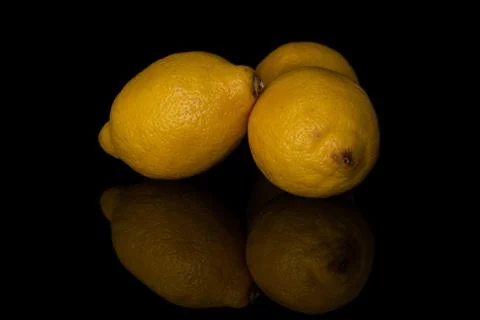 Fresh yellow lemon isolated on black glass Stock Photos