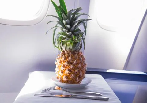 Fresh yellow pineapple on the table in the plane Stock Photos