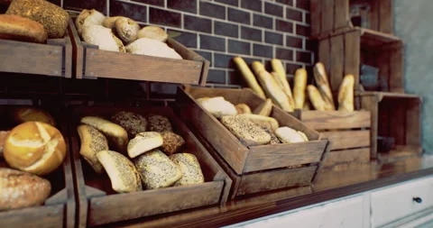 Freshly baked artisan bread displayed in rustic wooden crates at bakery Stock Footage 318420347