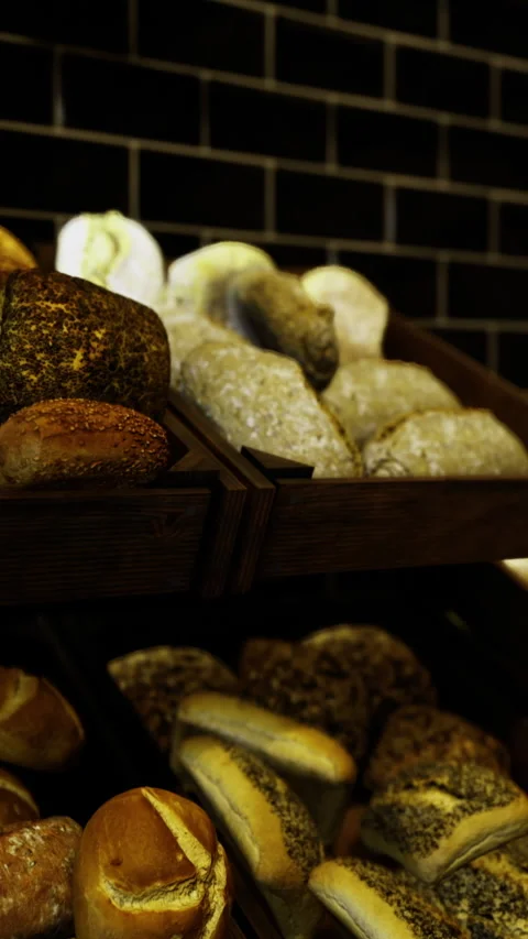 Freshly baked artisan bread displayed in a cozy bakery at dusk Stock Footage 318439506