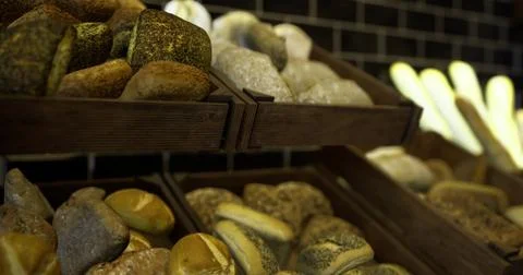 Freshly baked artisan bread in a rustic bakery display during daytime Stock Illustration
