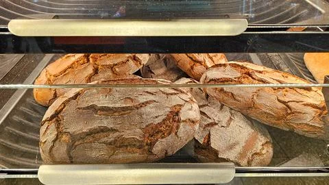 Freshly baked artisan rye bread loaves in a bakery display Stock Photos