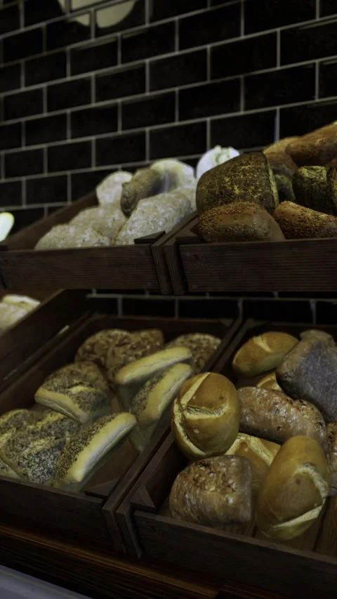 Freshly baked artisanal bread displayed in wooden crates in a bakery Stock Footage 325074251