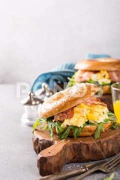 Freshly baked bagel filled with scrambled eggs Stock Photos