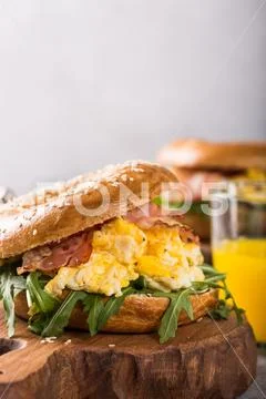 Freshly baked bagel filled with scrambled eggs Stock Photos