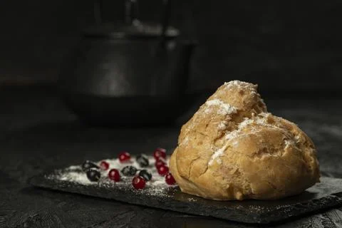 Freshly baked big eclair on a black cutting board Stock-Fotos