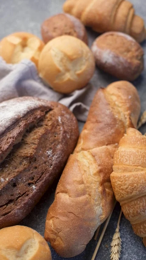 Freshly baked bread assortment on a concrete table Stock Footage 335807414