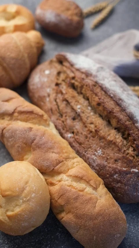Freshly baked bread assortment on a concrete table Stock Footage 335807419