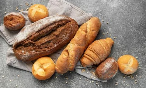 Freshly baked bread assortment on rustic grey background Stock Photos