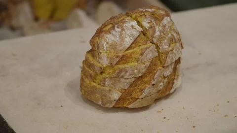 Freshly baked bread being cut with a knife Stock Footage 327429748