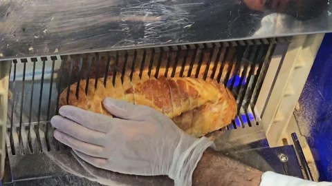 Freshly baked bread being processed by an industrial slicing machine. Stock Footage 311885281
