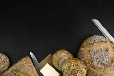 Freshly baked bread on a black background. Copy space. Stock Photos