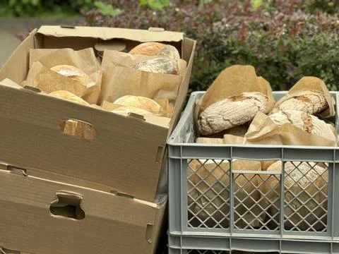 Freshly baked bread in boxes and crates outdoors, perfect for bakery or foo.. Stock Photos