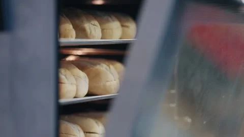 Freshly baked bread buns cooling in a commercial oven at the bakery Stock Footage 345756612