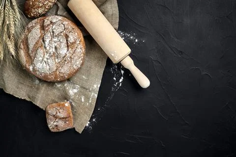 Freshly baked bread on dark kitchen table, top view Stock Photos